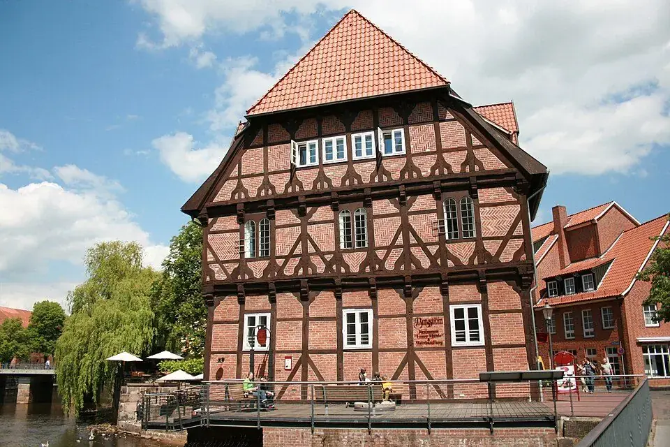 Lüner Mühle am Alten Hafen: Fachwerkhaus mit vorkragenden Geschossen und steilem Ziegeldach, davor die Terrasse am Wasser